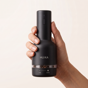 Dłoń trzymająca czarny młynek HU.KA Pulse Premium Wood — oznaczenia FINE i COARSE
